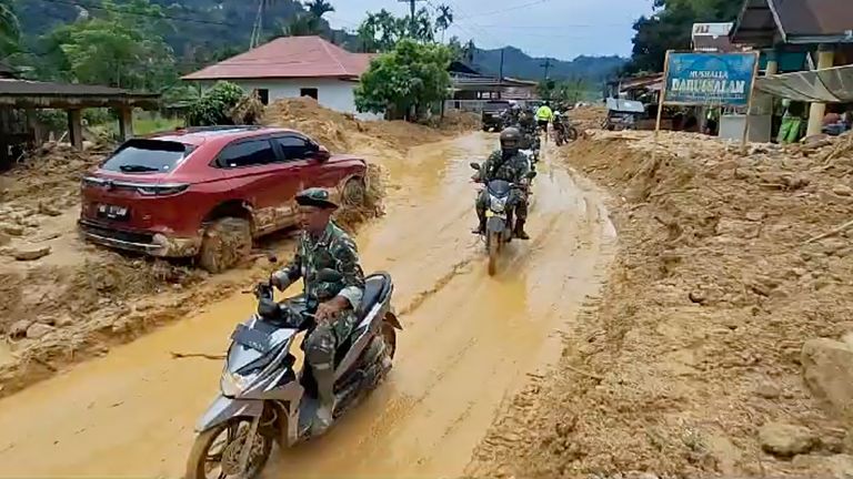 Soldiers ride motorbikes in a village affected by flash flood in West Sumatra. Pic: AP