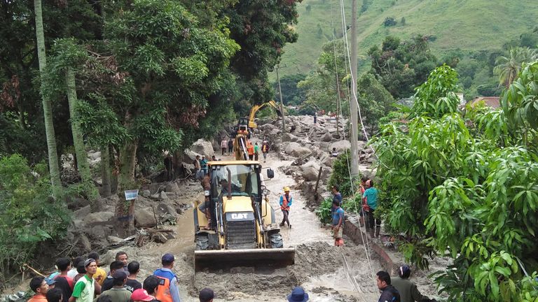 Rescue workers use heavy machines to clear a road from rock and mud following a landslide in Simangulampe village, North Sumatra, Indonesia, Saturday, Dec. 2, 2023. Torrential rain triggered flash floods and a landslide on Indonesia&#39;s Sumatra island, leaving a number of people missing, officials said Saturday. (AP Photo/Hermanto Tobing)