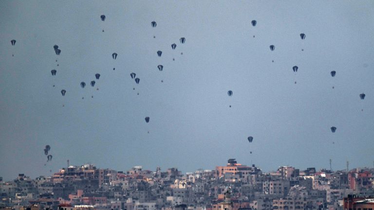 Parachutes drop supplies into the northern Gaza Strip, as seen from southern Israel.
Pic:AP