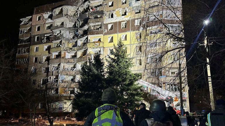 Police officers stand in a front of an apartment building damaged by a Russian missile strike on Kryvyi Rih. Pic: Reuters 