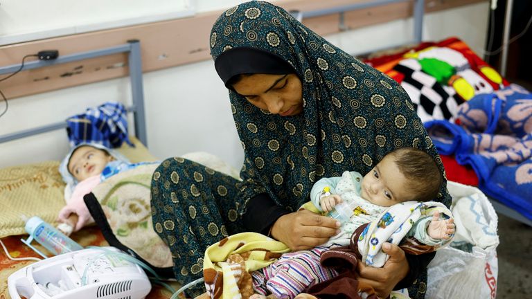 A Palestinian woman cares for her malnourished children at At al-Awda health centre in Rafah. Pic: Reuters