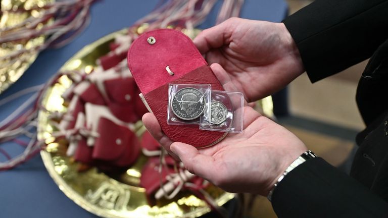 Red purses which contain a £5 coin which features the image of a Tudor dragon and King Charles III, and a 50p coin commemorating the RNLI, which Queen Camilla will distribute during the Royal Maundy service at Worcester Cathedral. Picture date: Thursday March 28, 2024.
