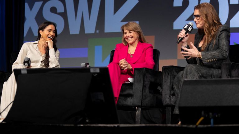 Meghan, Duchess of Sussex, left, and Katie Couric, centre, react as Brooke Shields, right, tells a story during a keynote on women&#39;s representation in media and entertainment on International Women&#39;s Day 2024. Pic: REUTERS/Nuri Vallbona