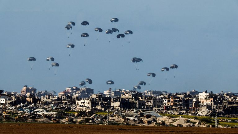 Packages dropped from a military aircraft fall towards northern Gaza, as seen from Israel.
Pic: Reuters
