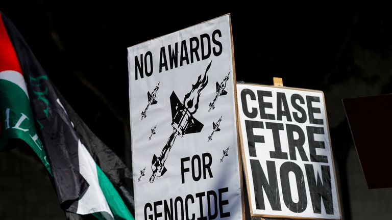 Protesters hold posters during a demonstration in support of Palestinians calling for a ceasefire in Gaza as the 96th Academy Awards Oscars ceremony is held nearby, Sunday, March 10, 2024, in the Hollywood section of Los Angeles. (AP Photo/Etienne Laurent)