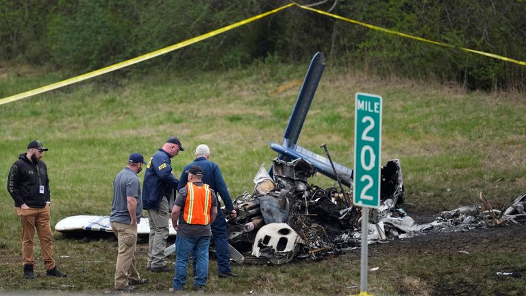 Investigators at the scene of the plane crash alongside Interstate 40. Pic: AP