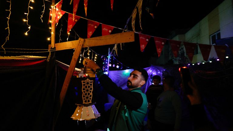A man hangs a lantern as displaced Palestinians prepare their tents for Ramadan, amid the ongoing conflict between Israel and the Palestinian Islamist group Hamas, in Rafah, in the southern Gaza Strip March 9, 2024. REUTERS/Mohammed Salem