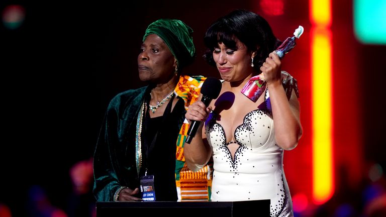 Raye (right) on stage with her grandmother after winning the Mastercard Album of the Year award during the Brit Awards 2024 at the O2 Arena, London. Picture date: Saturday March 2, 2024. PA Photo. See PA story SHOWBIZ Brits. Photo credit should read: James Manning/PA Wire