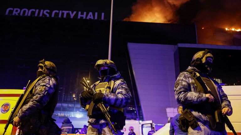 Russian authorities stand guard near the burning Crocus City Hall concert venue. Pic: Reuters
