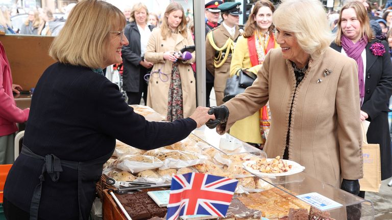 Queen Camilla smiles and shakes hands with a market trader during her visit to the Farmers&#39; Market, in Shrewsbury.
Pic: Reuters
