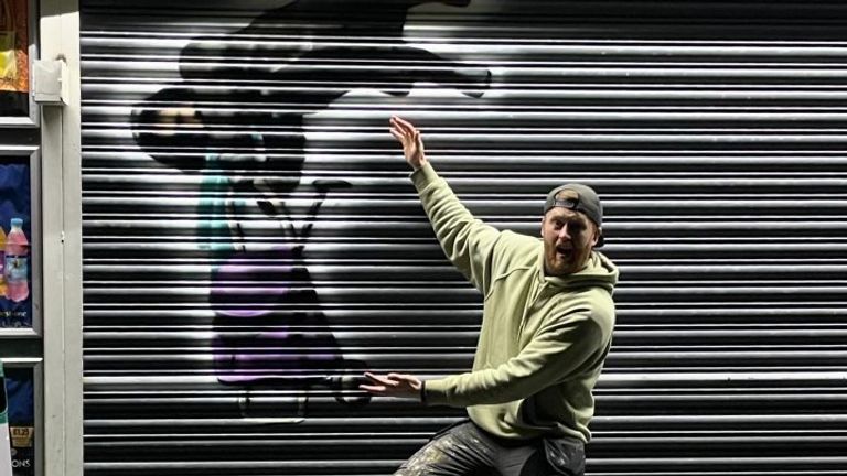 Ο καλλιτέχνης γκράφιτι Tee2Sugars δίπλα στην τοιχογραφία του στο Rhondda Cynon Taf.