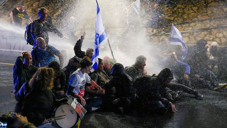 Police use water cannon to disperse demonstrators during a protest against Israeli Prime Minister Benjamin Netanyahu&#39;s government, and calling for the release of hostages held in the Gaza Strip by the Hamas militant group, in Tel Aviv, Israel, Saturday, March 9, 2024. (AP Photo/Ariel Schalit)