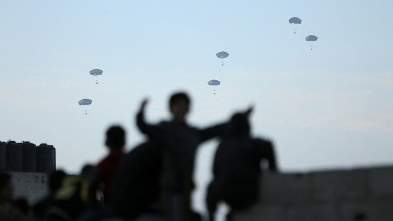 People watch as US military carries out its first aid drop over Gaza. Pic: Reuters