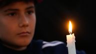 A boy holds a candle at a vigil for the victims of the Bondi shopping mall stabbing. Pic: AP