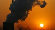 FILE PHOTO: The sun sets next to a smokestack from a coal-burning power station in Beijing January 9, 2008. REUTERS/David Gray/File Photo