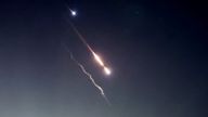 Objects are seen in the sky above Jerusalem after Iran launched drones and missiles towards Israel in Jerusalem