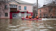 Emergency workers ride a boat to evacuate Russians trapped by flooding. Pic: AP