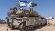 An Israeli soldier attaches an Israeli flag on top of an armoured personnel carriers (APC) near Israel&#39;s border with Gaza, in southern Israel, Monday, April 15, 2024. (AP Photo/Ohad Zwigenberg)