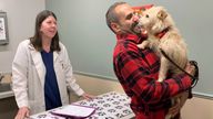 Mehrad Houman holds his dog, Mishka, after she was examined by veterinarian Nancy Pillsbury in Harper Woods, Mich., Friday, March 29, 2024. Mishka was discovered in suburban Detroit, eight months after disappearing in San Diego. (Corinne Martin via AP)