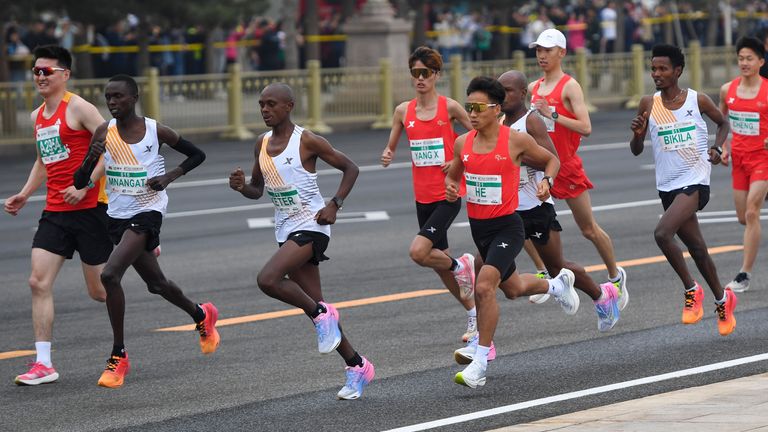 رکورددار ماراتن مردان چین در طول مسابقه در کنار دوندگان آفریقایی می دود.  عکس: AP