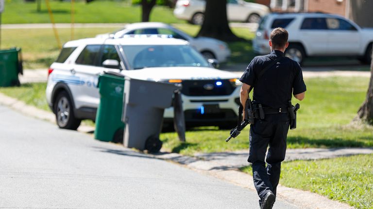 A Charlotte Mecklenburg police officer walks carrying a gun in the neighbourhood where a shooting took place in Charlotte, North Carolina., Monday, April 29, 2024. The Charlotte-Mecklenburg Police Department says officers from the U.S. Marshals Task Force were carrying out an investigation Monday afternoon in a suburban neighbourhood when they came under gunfire. (AP Photo/Nell Redmond)