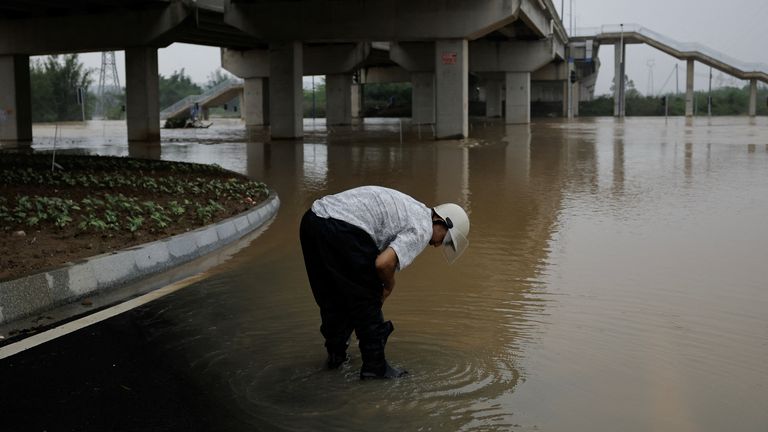 A man in floodwaters on a street following heavy rainfall at a village in Qingyuan, Guangdong province, China. Pic: Reuters
