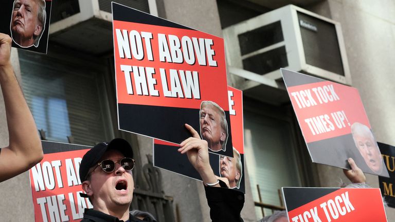 People hold signs against former U.S. President Donald Trump on the day of his hush money criminal trial, in New York, U.S. April 15, 2024. REUTERS/Brendan McDermid