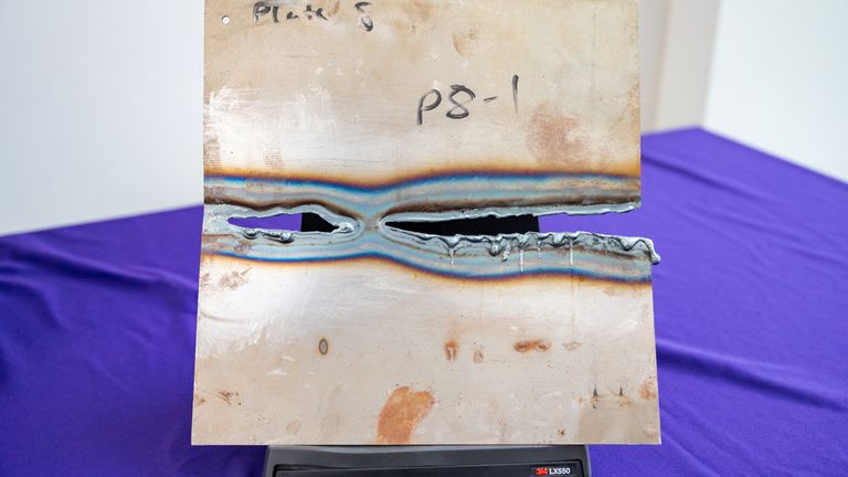 A metal plate showing damaged caused by 'DragonFire', a British military laser weapon system