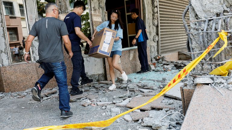 People carry merchandise and valuables from a bicycle store in a damaged building after the earthquake, in Hualien.
Pic: Reuters