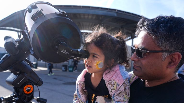 A young girl peers through a telescope at the Indianapolis Motor Speedway. Pic: AP