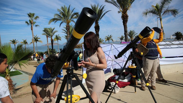 People prepare their telescopes in Mazatlan, Mexico to observe a total solar eclipse.
