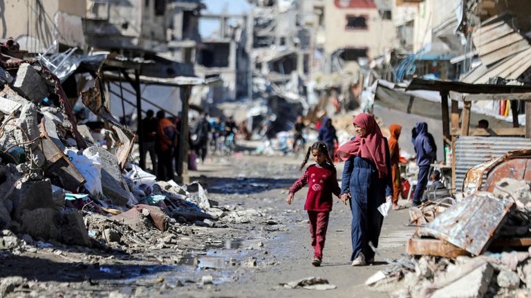 People walk in the ruins of houses in Gaza City in March. Pic: Reuters