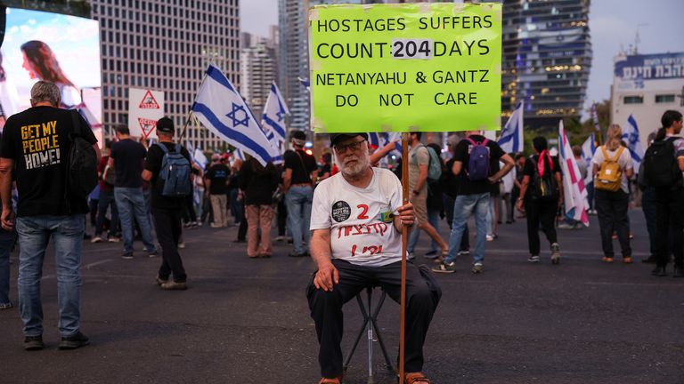 A man holds a placard as people attend a protest against Israeli Prime Minister Benjamin Netanyahu&#39;s government and to call for the release of hostages kidnapped in the deadly October 7 attack on Israel by the Palestinian Islamist group Hamas, in Tel Aviv, Israel, April 27, 2024. REUTERS/Shannon Stapleton
