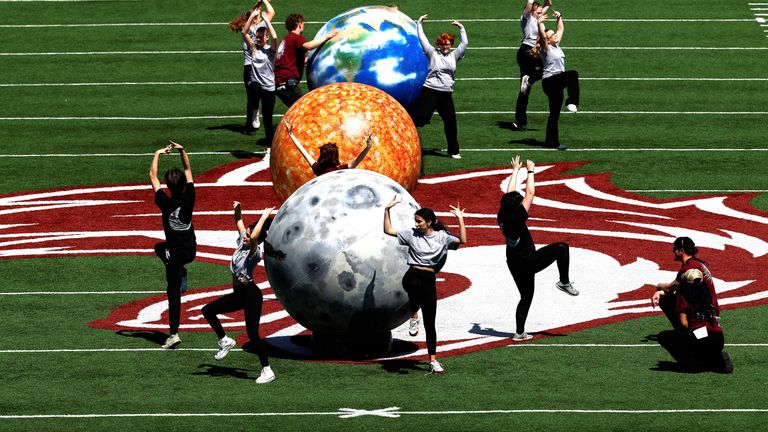 People dance next to models of the earth, sun and moon at Saluki Stadium in Illinois.
Pic: Reuters