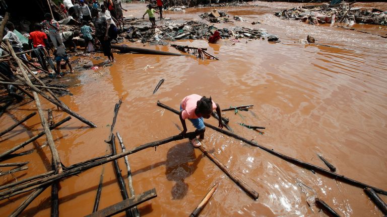 A girl wades through flood waters after the Nairobi river burst its banks and destroyed their home within the Mathare valley settlement. Pic: Reuters