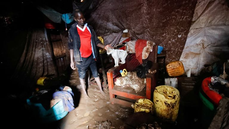 Diana Awino with her cat inside her house marooned in flood waters within the Mathare valley in Nairobi. Pic: Reuters