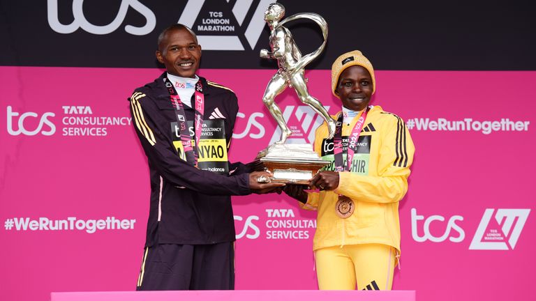 Alexander Mutiso Munyao and Peres Jepchirchir with their trophies and medals on the podium after winning the men&#39;s and women&#39;s elite races during the TCS London Marathon. Pic: PA 