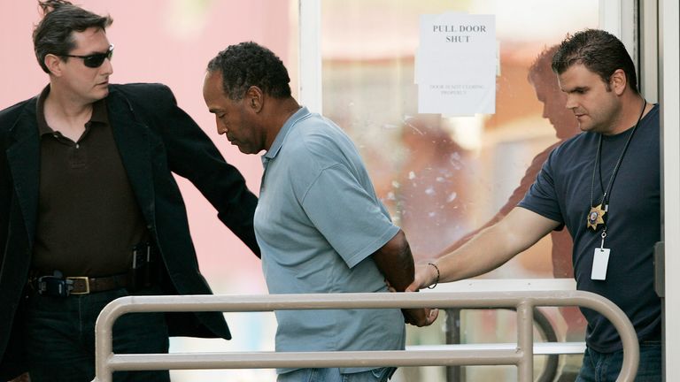 O.J. Simpson, center, is taken from the Las Vegas Police Investigative Services Division in Las Vegas, Sunday, Sept. 16, 2007. (AP Photo/John Locher)