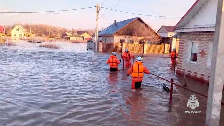Rescuers wade through floodwaters in Orsk