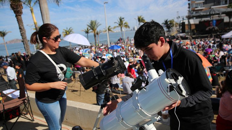 People  prepare their telescopes as people gather and wait to observe a total solar eclipse in Mazatlan, Mexico.
Pic: Reuters