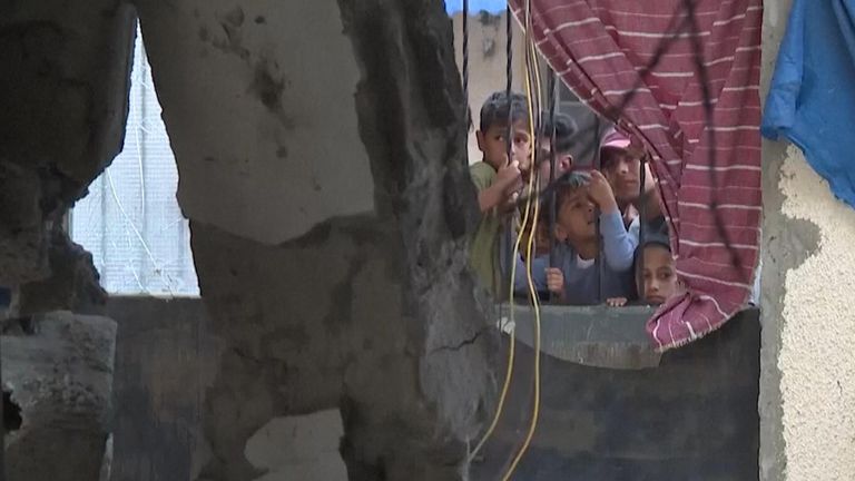 Children looking through window to destruction in Rafah