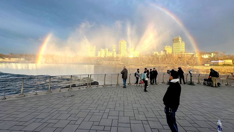 A Rainbow forms over Niagara Falls as people wait for a solar eclipse .
Pic: Reuters