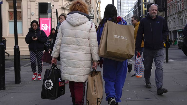 People walk along a street in a shopping district in central London, Friday, Jan. 13, 2023. The U.K. economy grew unexpectedly in November as the tight job market increased demand for employment services and soccer&#39;s World Cup boosted hospitality. (AP Photo/Kin Cheung)