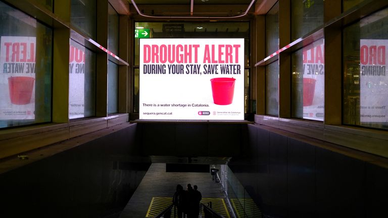 Tourists walk past a sign at Josep Tarradellas Barcelona-El Prat Airport alerting them of severe drought in Spain&#39;s northeastern region and urging them to save water due to low reservoir levels, as Catalonia declares state of emergency, in Barcelona, Spain, March 7, 2024. REUTERS/Nacho Doce