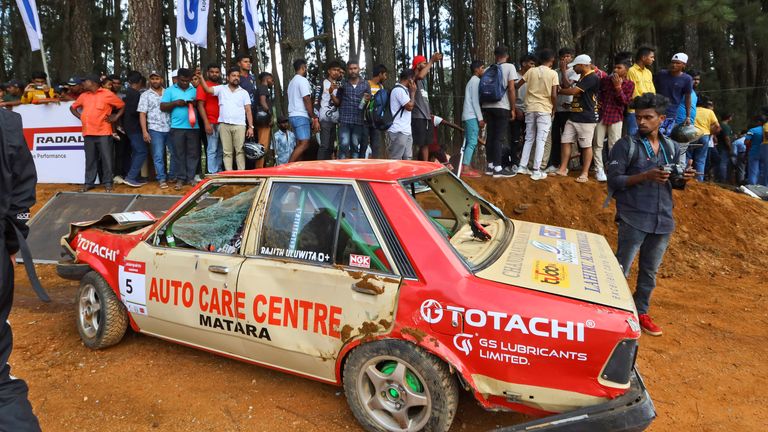 People gather around a car that had crashed into the spectators. Pic: AP