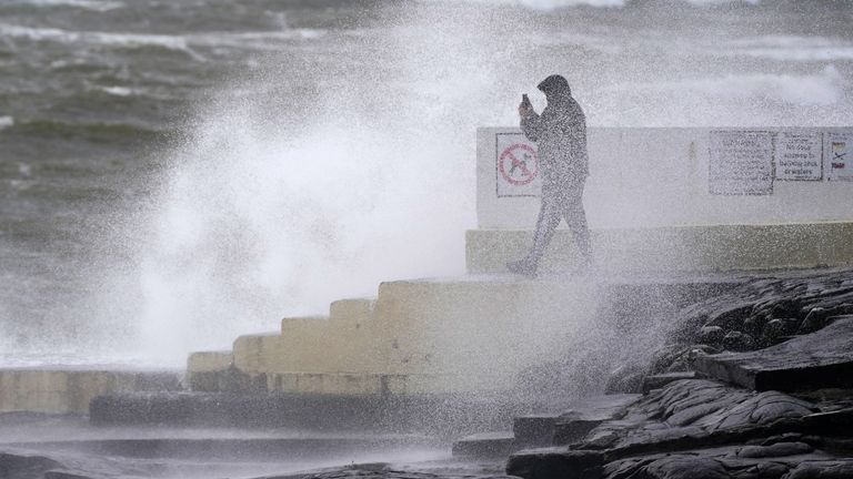 A man takes photos of the waves at Blackrock Diving Board, Salthill, Co Galway. Pic: PA
