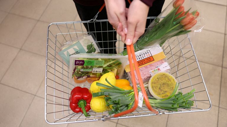 A customer carries a basket filled with food inside a Sainsbury’s supermarket in Richmond, West London, Britain February 21, 2024. REUTERS/Isabel Infantes/File Photo
