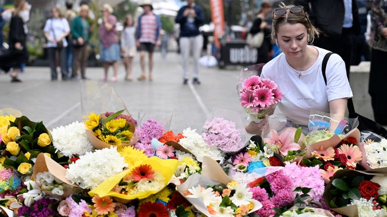 A woman pays her respect and lays flowers at the scene of Saturday&#39;s mass stabbing. Pic: Reuters