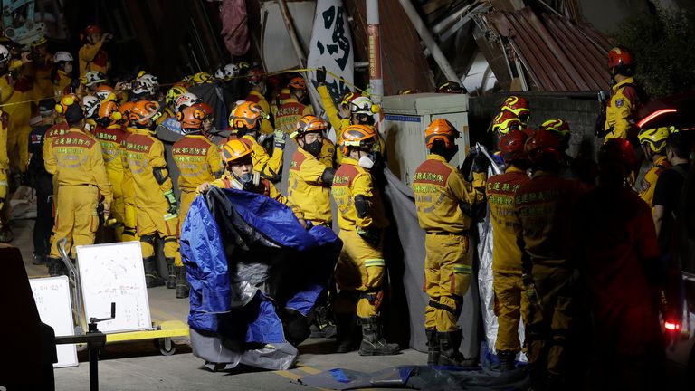 Emergency workers prepare to move victims' bodies outside a collapsed building in Hualien. Pic: AP