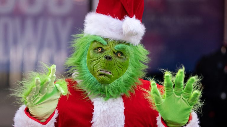 A person dressed as the Grinch in Times Square poses for photos in New York City, U.S., December 9, 2022. REUTERS/David &#39;Dee&#39; Delgado